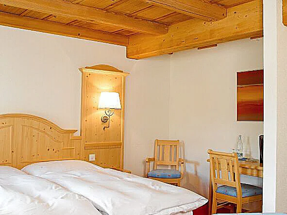 Doppelzimmer mit Holzdecke, Holzbett und heller Einrichtung