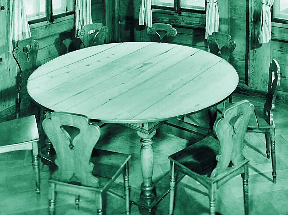 Runder Holztisch mit Stuhlreihe