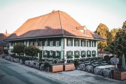 Gasthof Bären in Dürrenroth, grosses Haus mit Walmdach und bepflanzter Terrasse