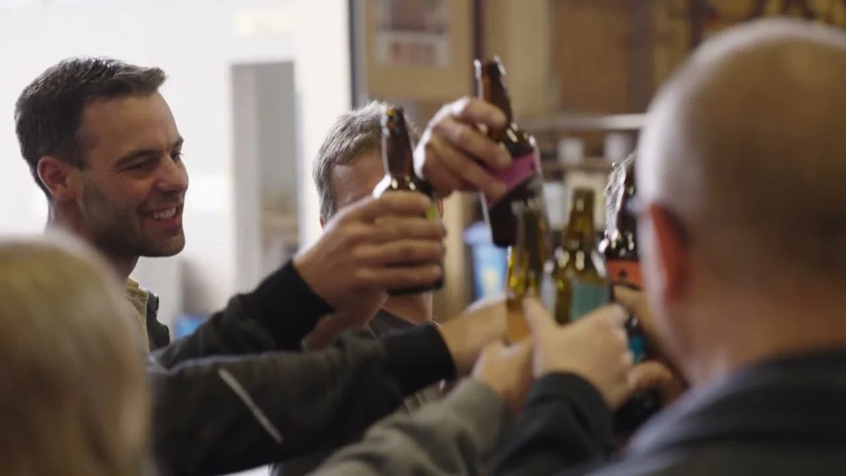 Szene aus dem Emmental-Imagefilm: Menschen stossen mit Bierflaschen an